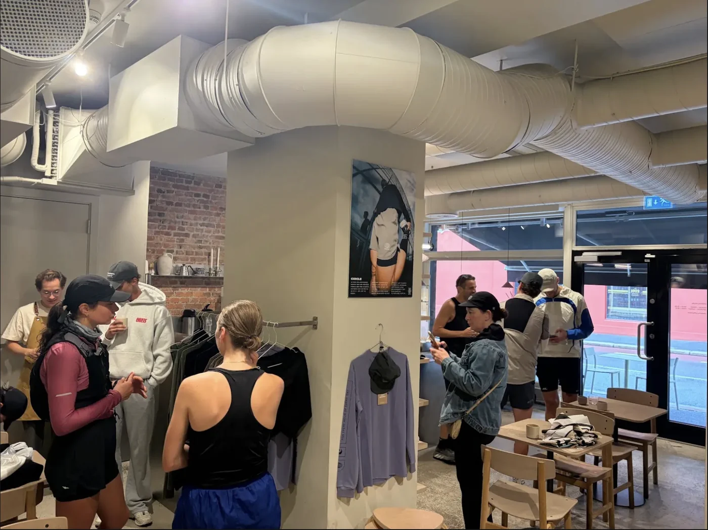 Run club members browsing Circle Sportswear clothing inside a Hakone Coffee cafe